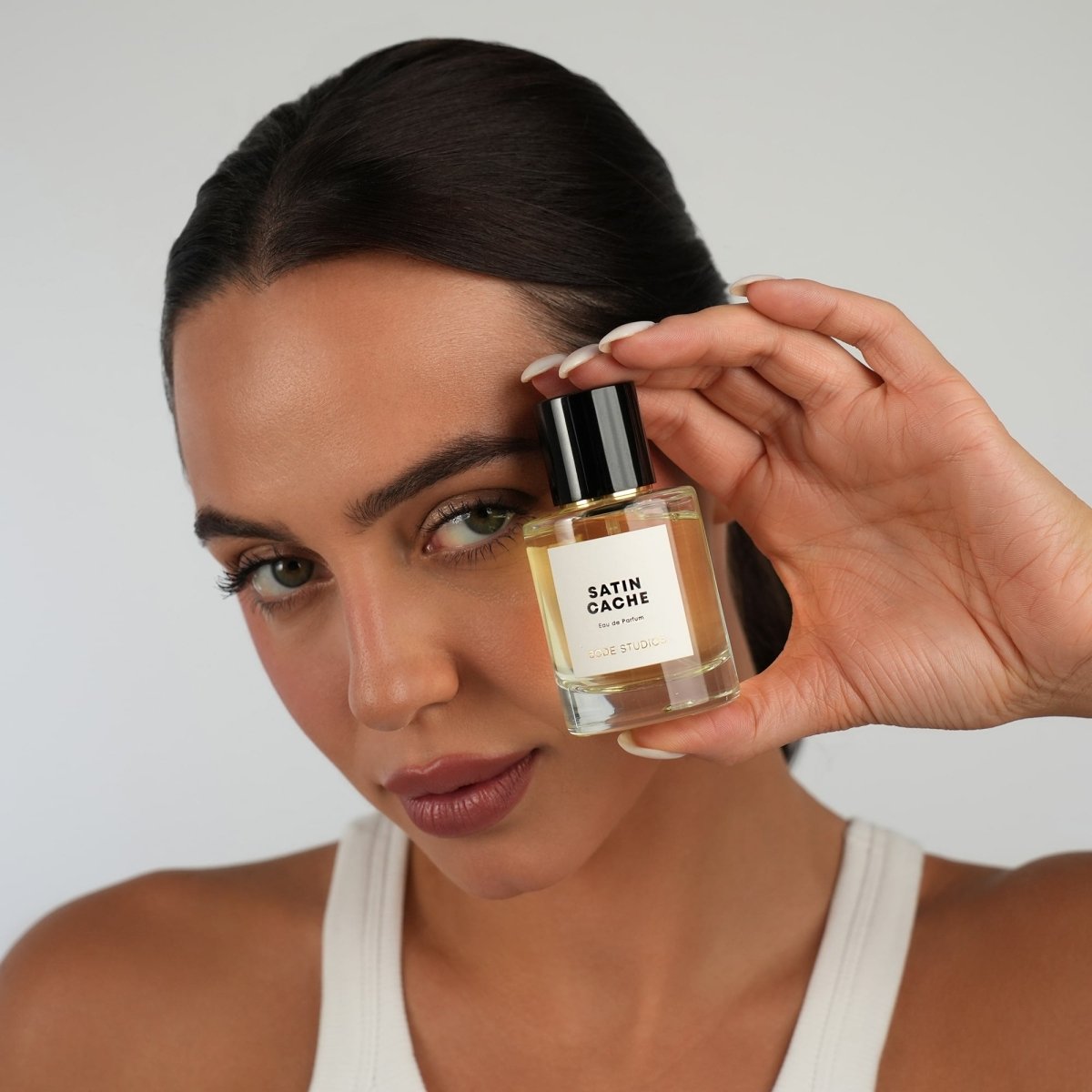woman holding up SATIN CACHE Eau de Parfum by BODÉ STUDIOS